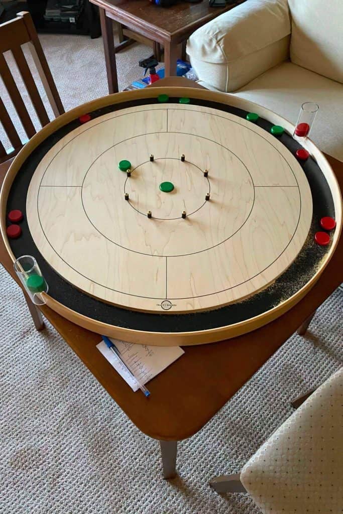 Green and red buttons on a maple crokinole board
