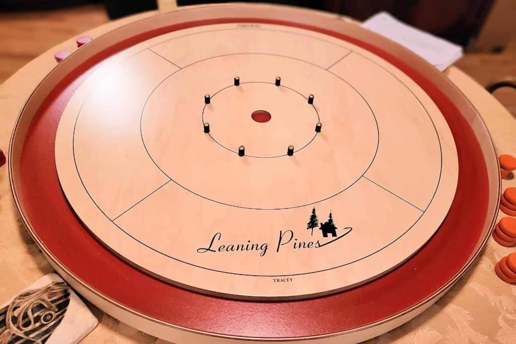 Custom Red Tracey Crokinole Board with the Leaning Pines logo on the playing surface