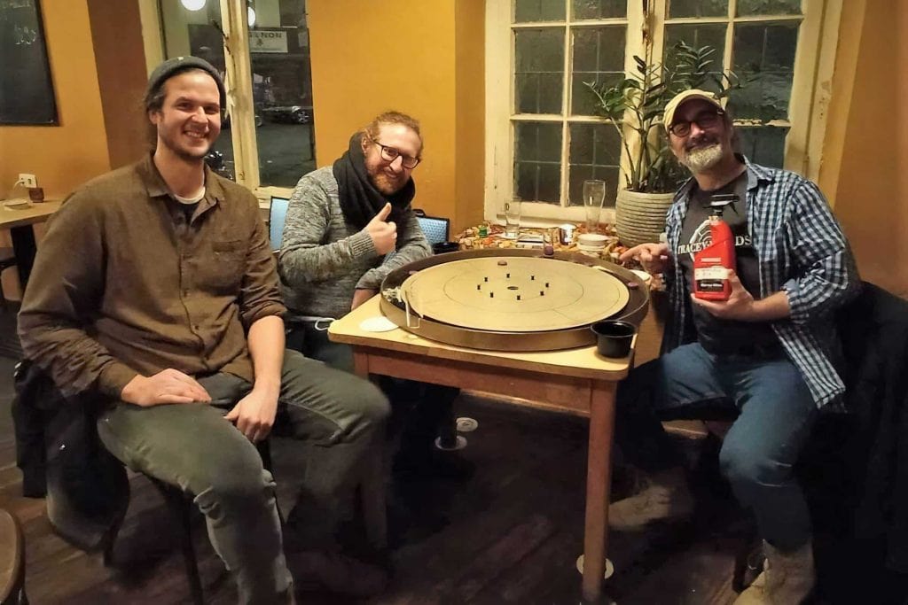 Holger Schulz and friends waxing a greyrock Tracey crokinole board
