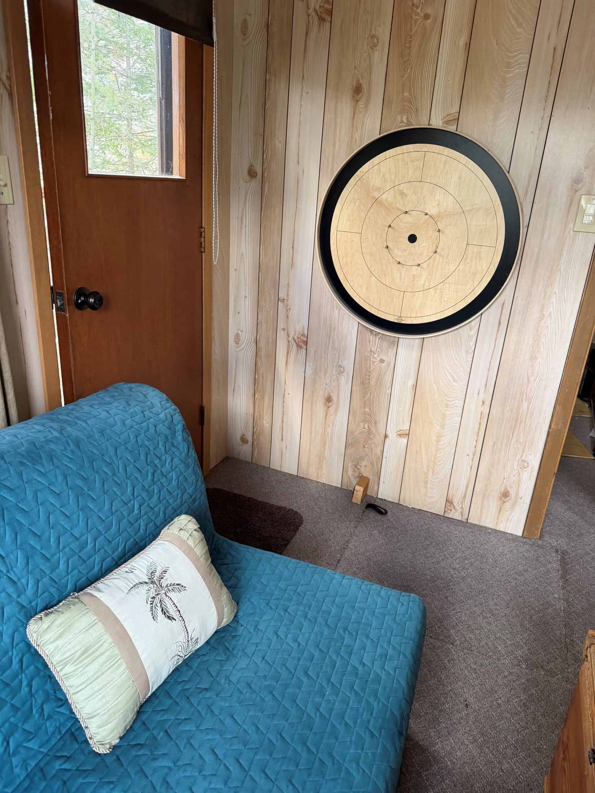 A black Tracey Crokinole Board on a wall mount