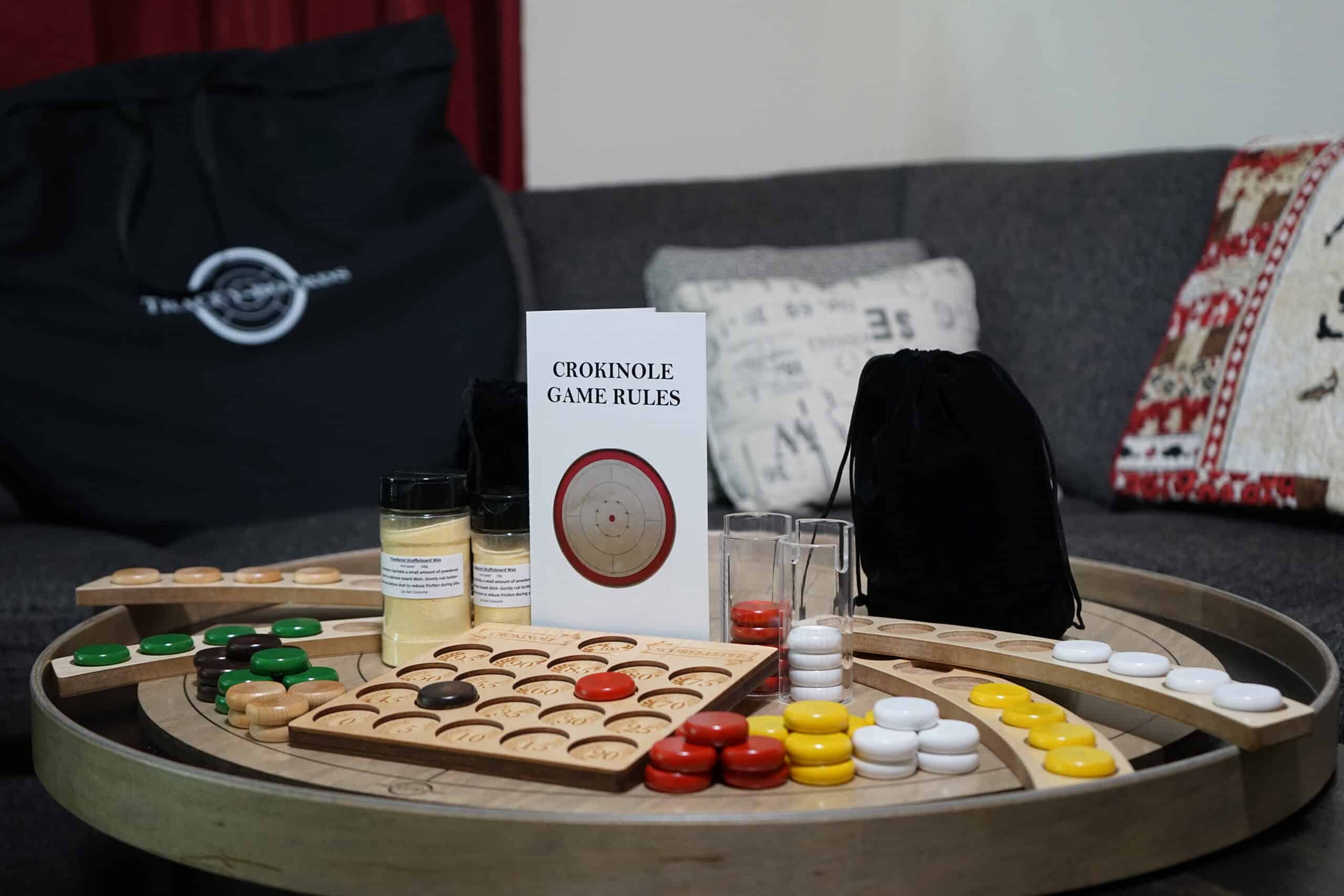 a grey rock crokinole board with the ultimate package accessories